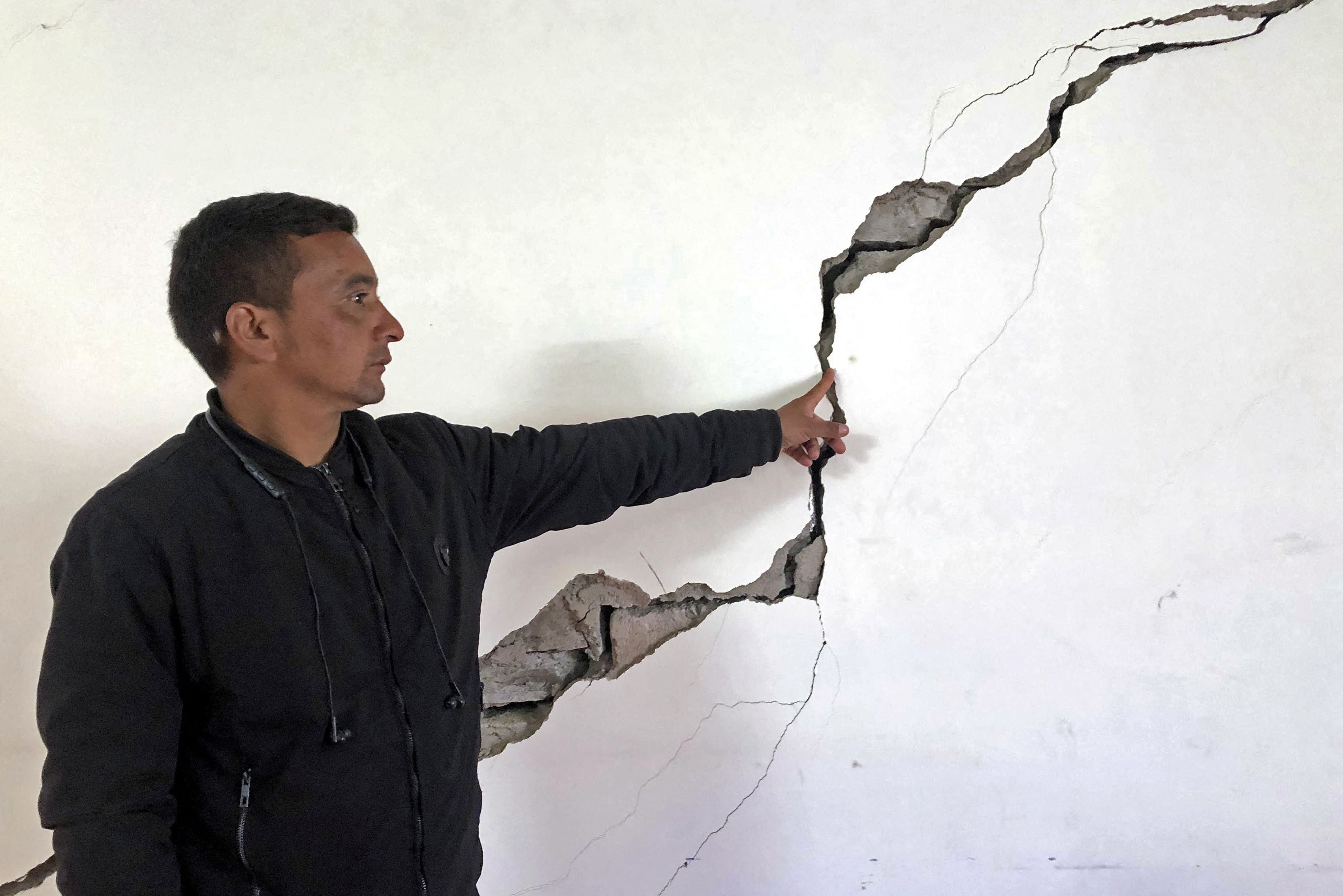 A resident shows a crack on the wall of his house at Joshimath