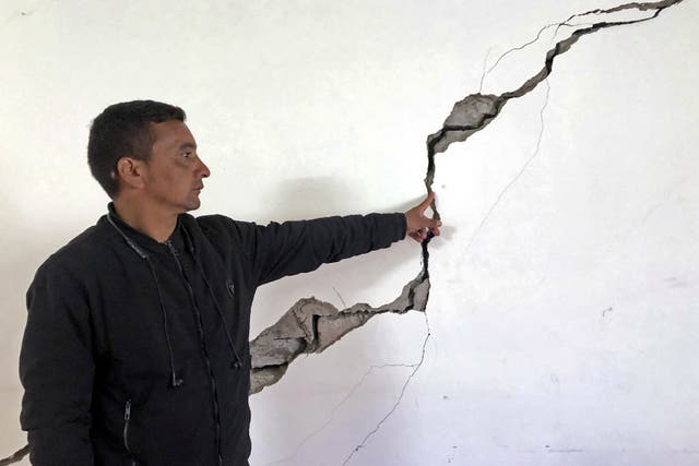 <p>A resident shows a crack on the wall of his house at Joshimath</p>