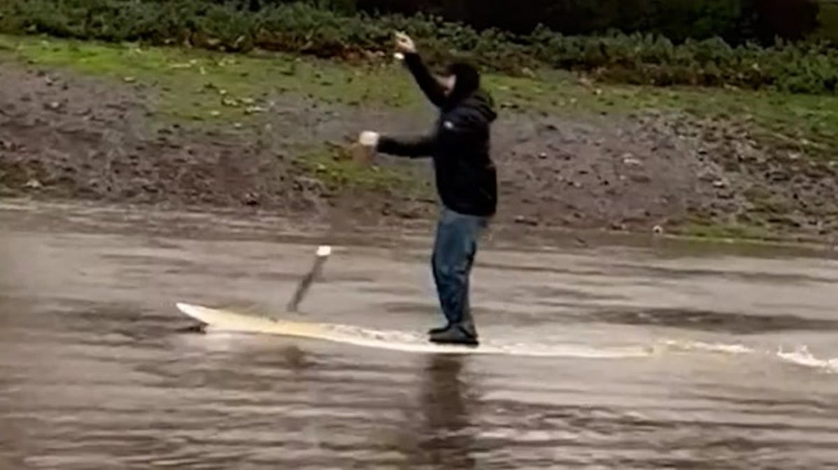 California resident paddleboards through flooded street as state hit by devastating storm