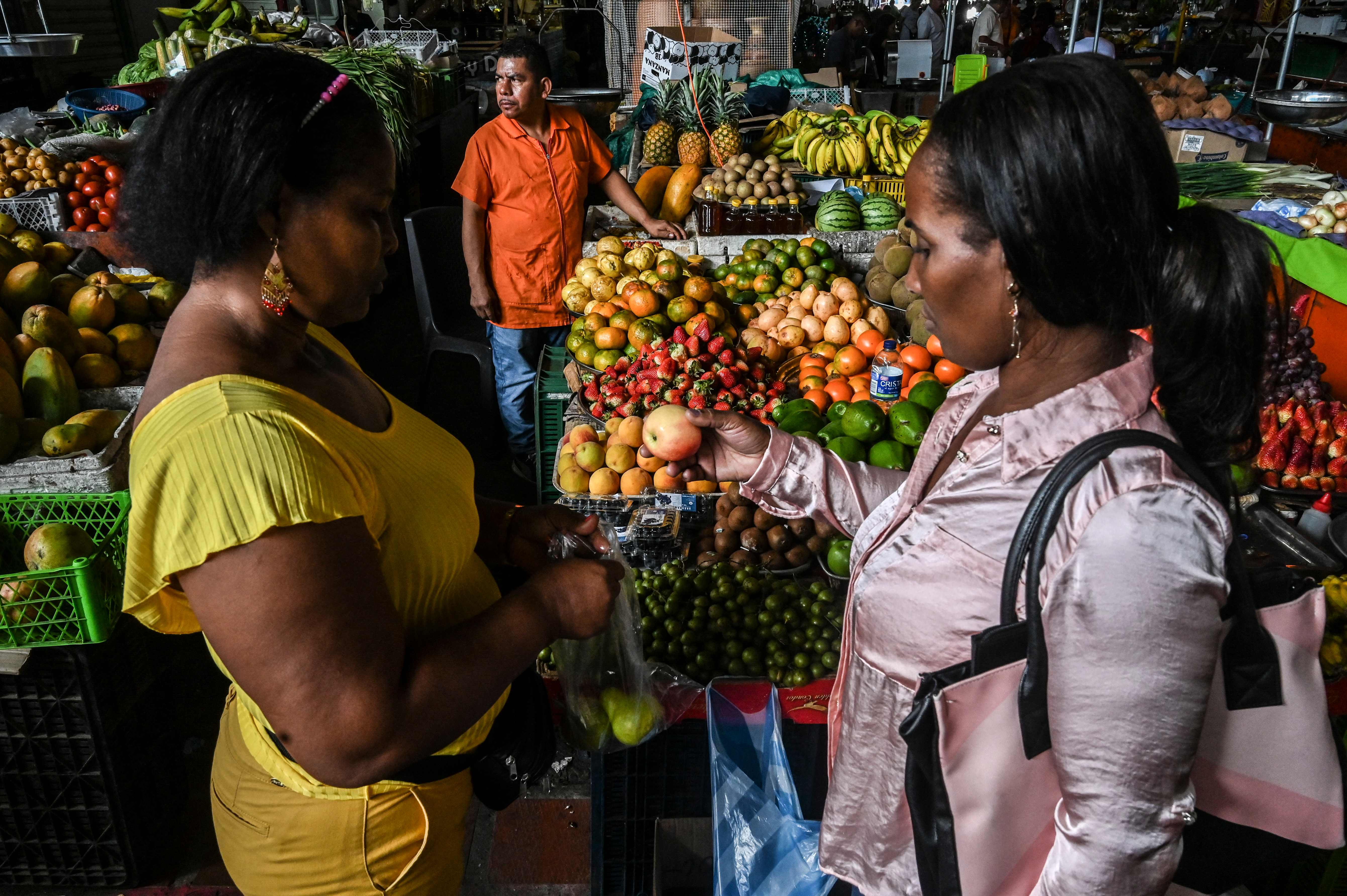 Shoppers buy fruit at a market in Cali, Colombia last week