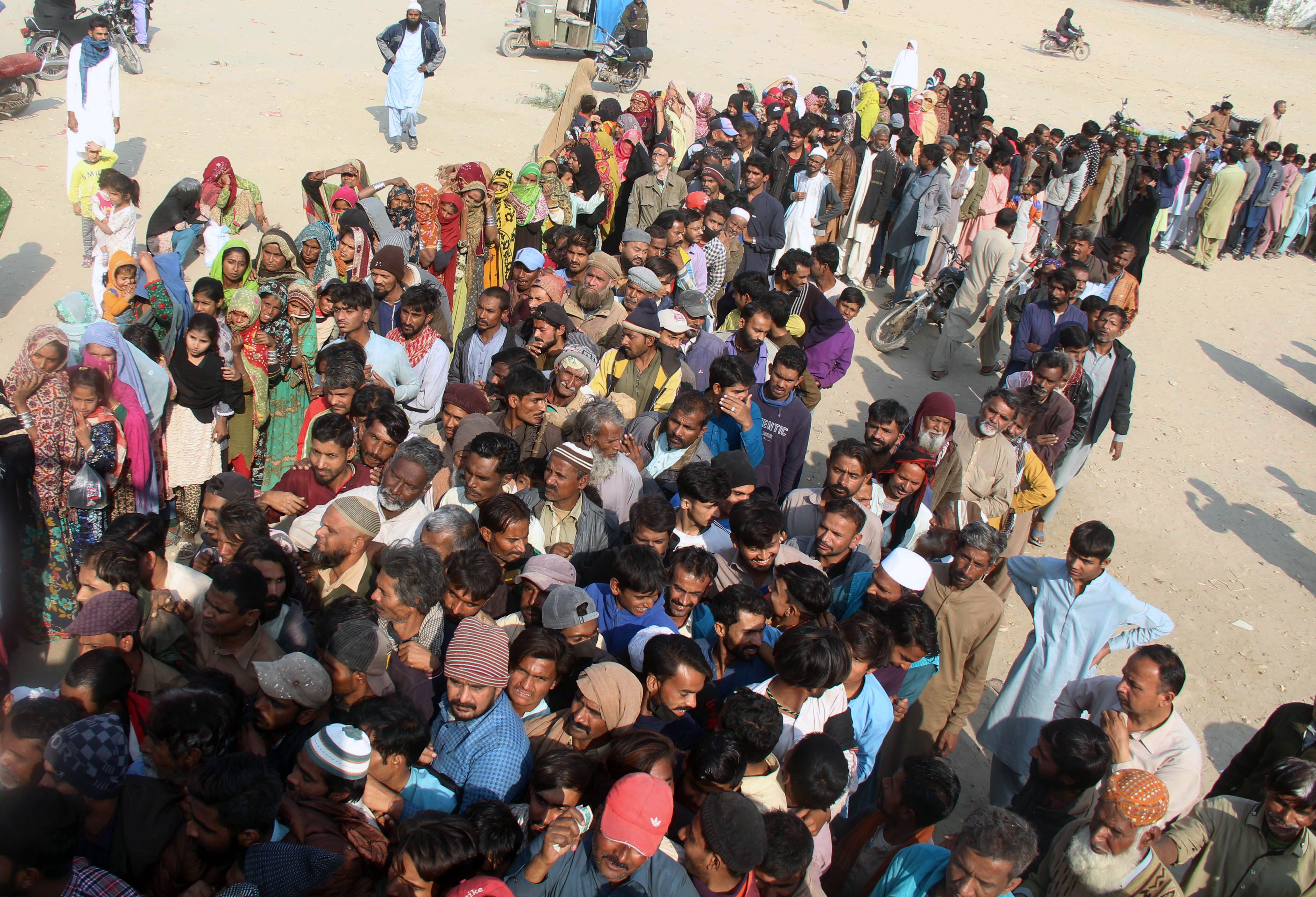 Pakistanis queue for wheat flour in Hyderabad, after supply disruptions caused by the Ukraine war sent prices soaring