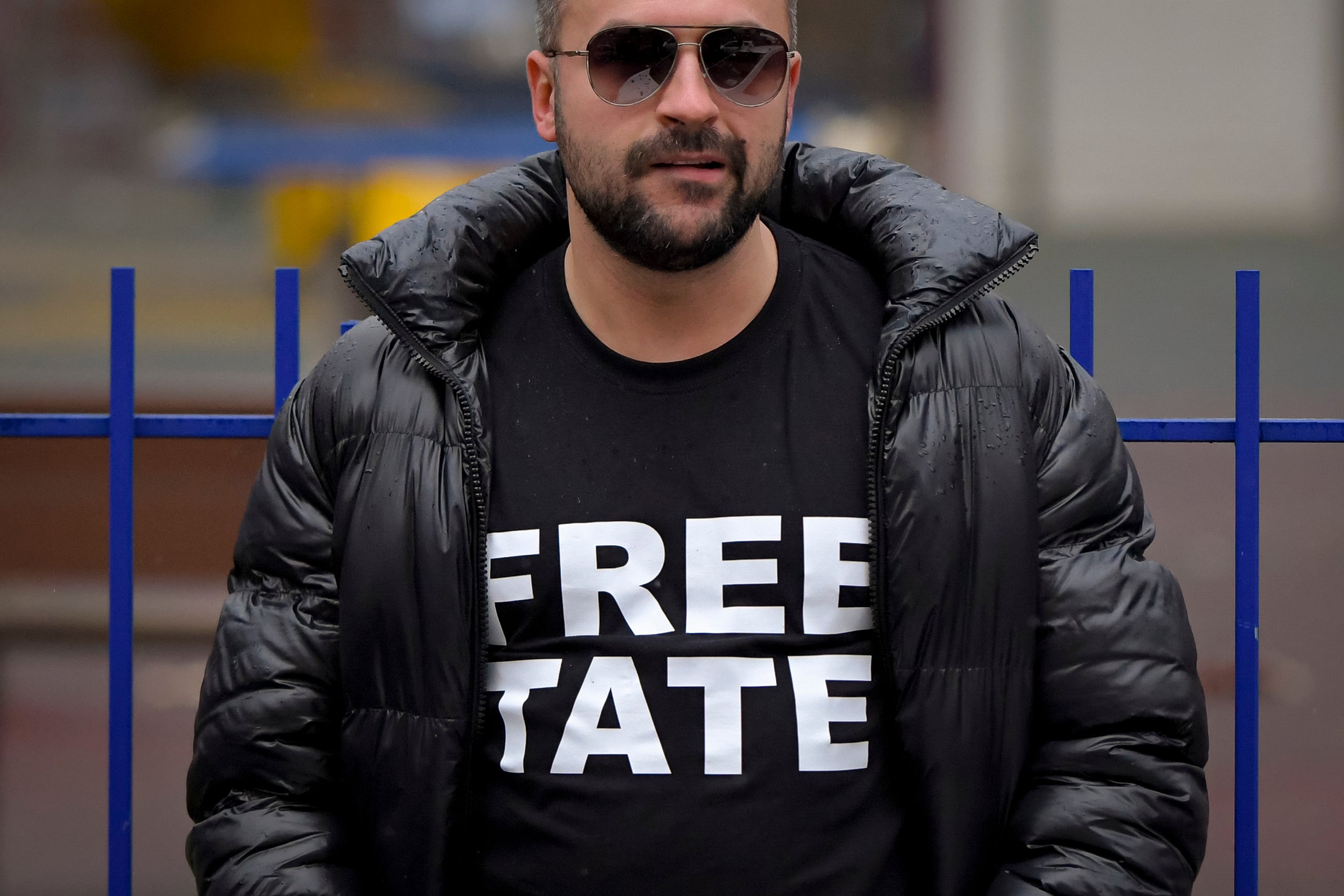 A Tate supporter stands outside court during the hearings