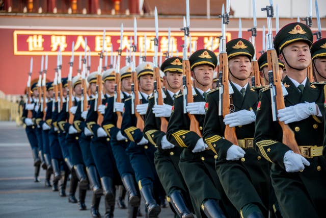 <p> The Guard of Honor of the Chinese People’s Liberation Army (PLA) escorts the national flag during a flag-raising ceremony at the Tiananmen Square</p>