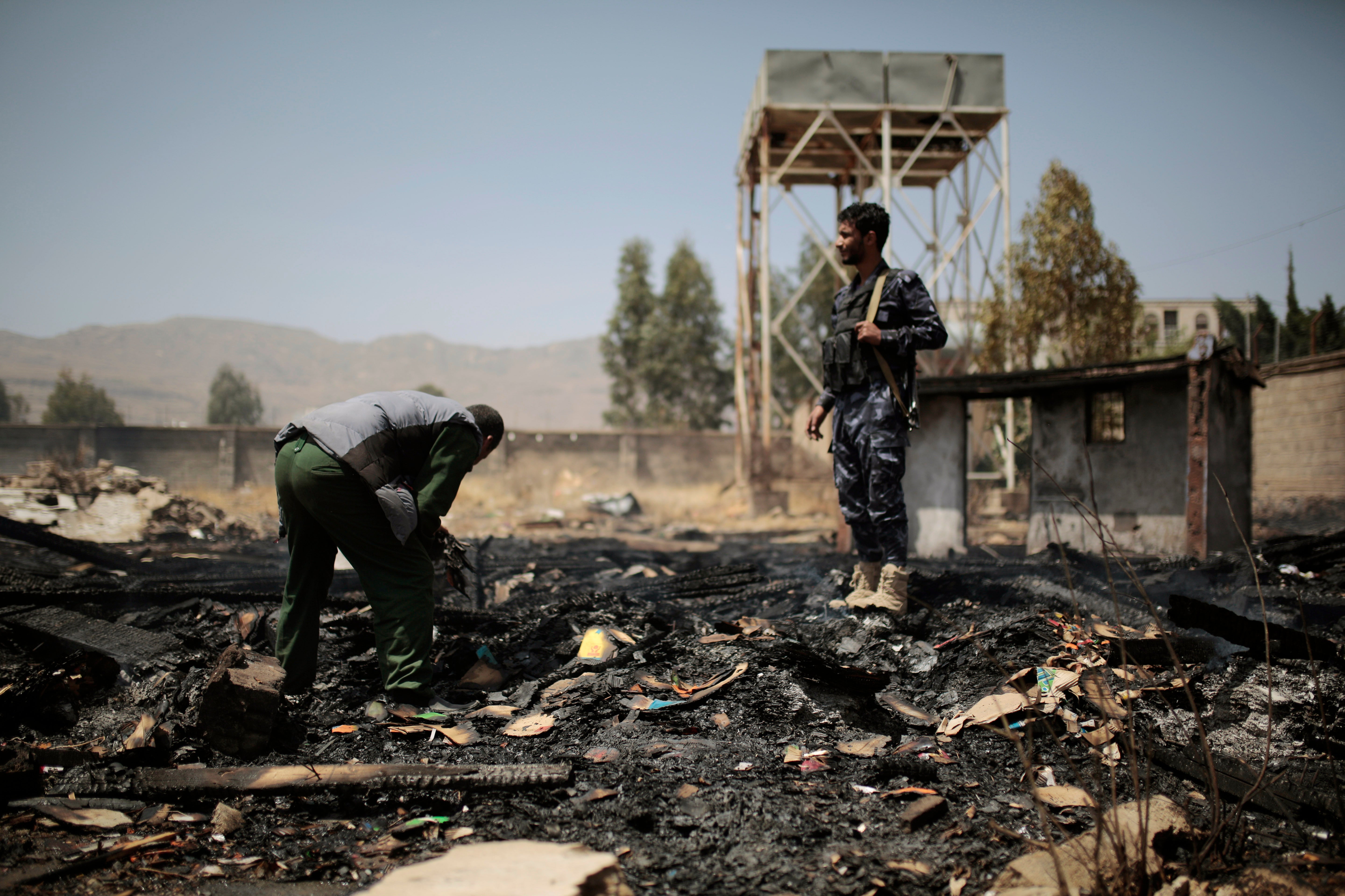 <p>Yemeni police inspect a site of a Saudi-led airstrike in Sanaa last year </p>