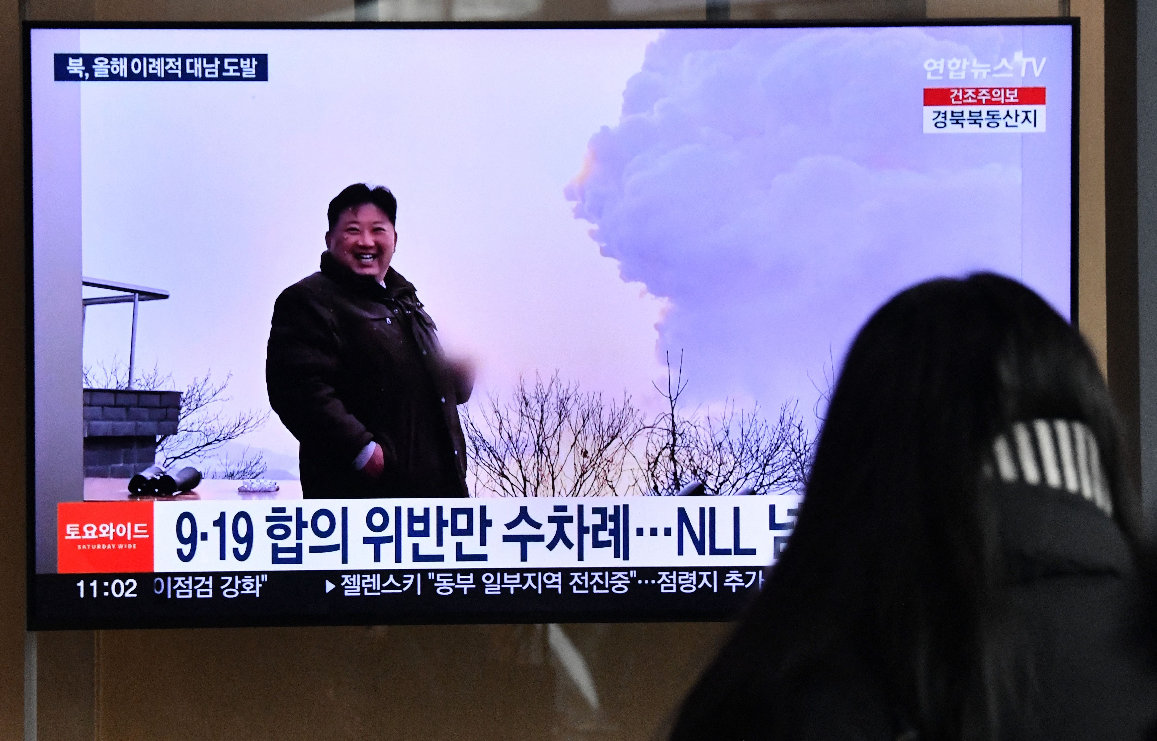 File. A woman watches a television screen showing a news broadcast with file footage of North Korean leader Kim Jong Un, at a railway station in Seoul on 31 December 2022 after North Korea fired three short-range ballistic missiles according to South Korea's military
