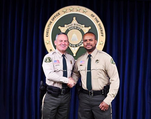 <p>Deputy Darnell Calhoun, right, poses with Riverside County Sheriff Chad Biano</p>