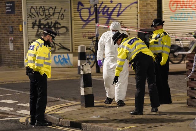 <p>A police forensics officer works near to the scene of a suspected drive-by shooting in Phoenix Road, next to London’s Euston station </p>