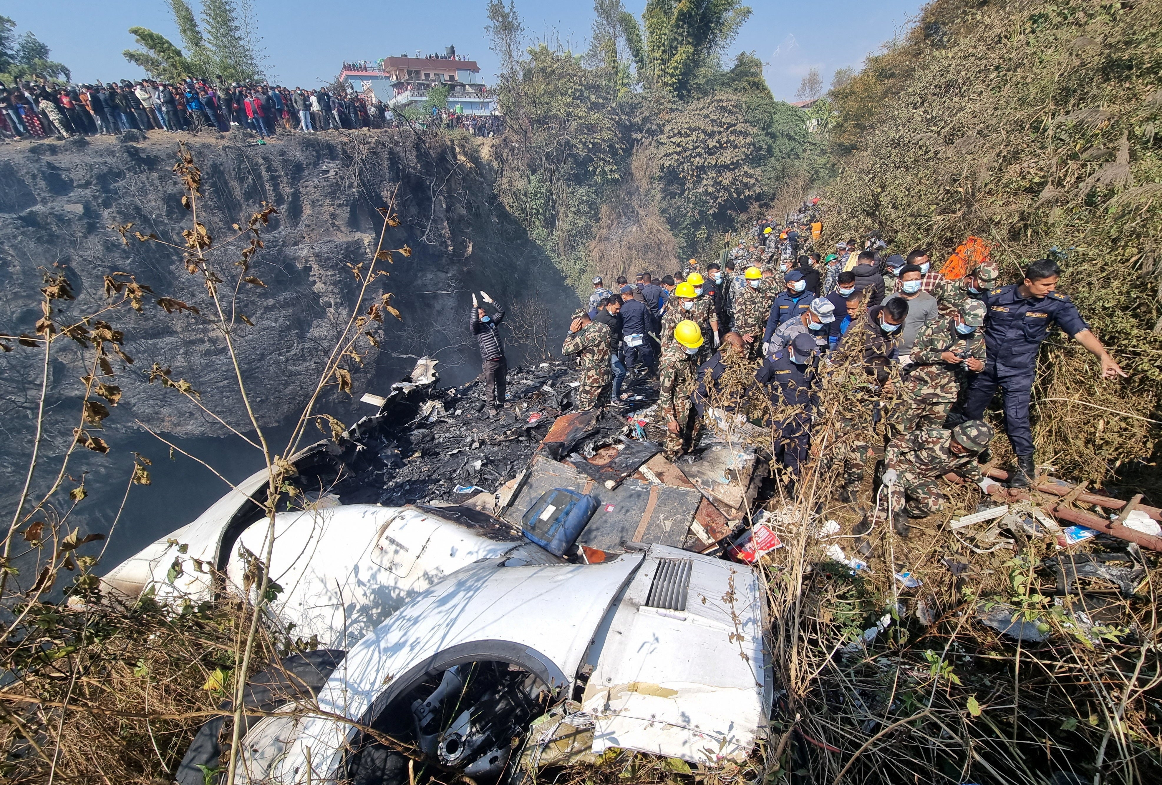 <p>Rescue teams work to retrieve bodies at the crash site of an aircraft carrying 72 people in Pokhara, Nepal</p>