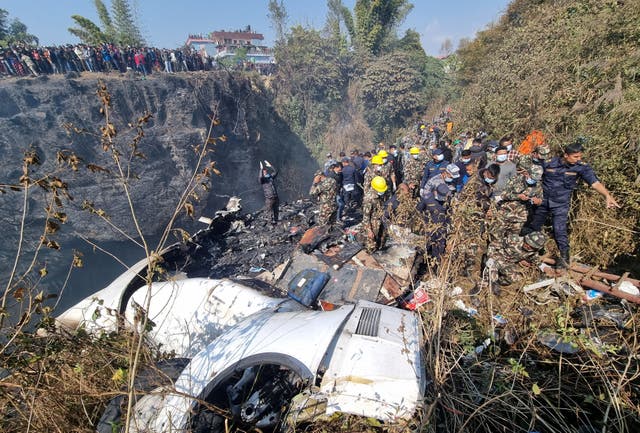 <p>Rescue teams work to retrieve bodies at the crash site of an aircraft carrying 72 people in Pokhara, Nepal</p>