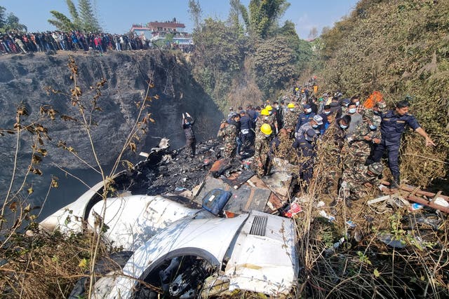 <p>Rescue teams work to retrieve bodies at the crash site of an aircraft carrying 72 people in Pokhara, Nepal</p>