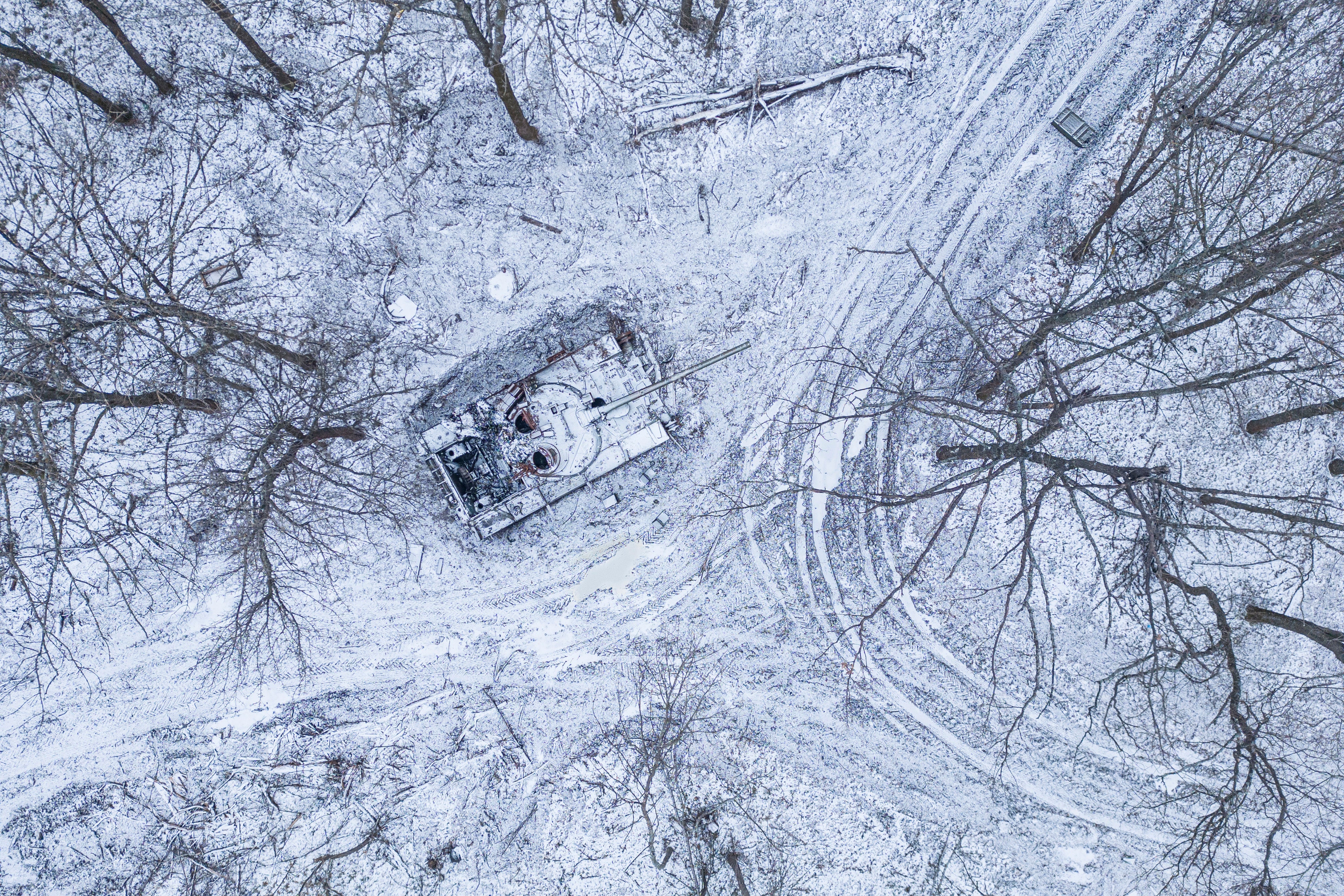A destroyed Russian tank covered by snow stands in a forest in the Kharkiv region, Ukraine