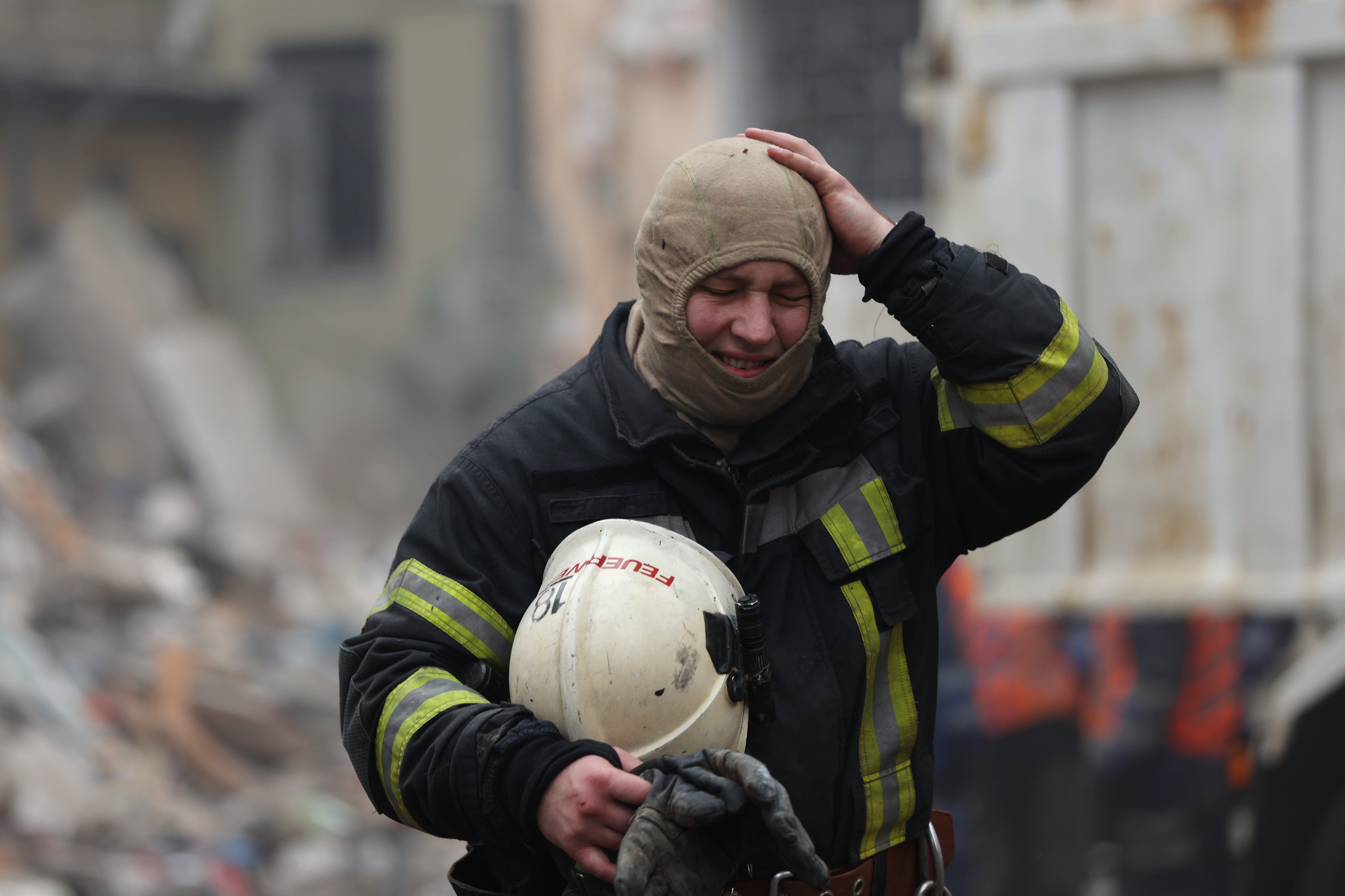 A firefighter walks away as emergency workers search the remains of a residential building that was struck by a Russian missile in Dnipro on Saturday