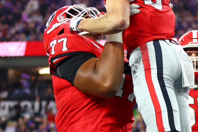 <p>Georgia Bulldogs offensive lineman Devin Willock (77) lifts up wide receiver Ladd McConkey (84) after he scored a touchdown</p>