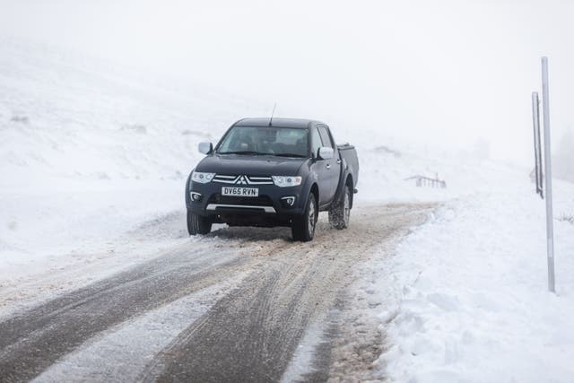 A car makes it way along the A939 after heavy snowfall in the Cairngorms (PA)