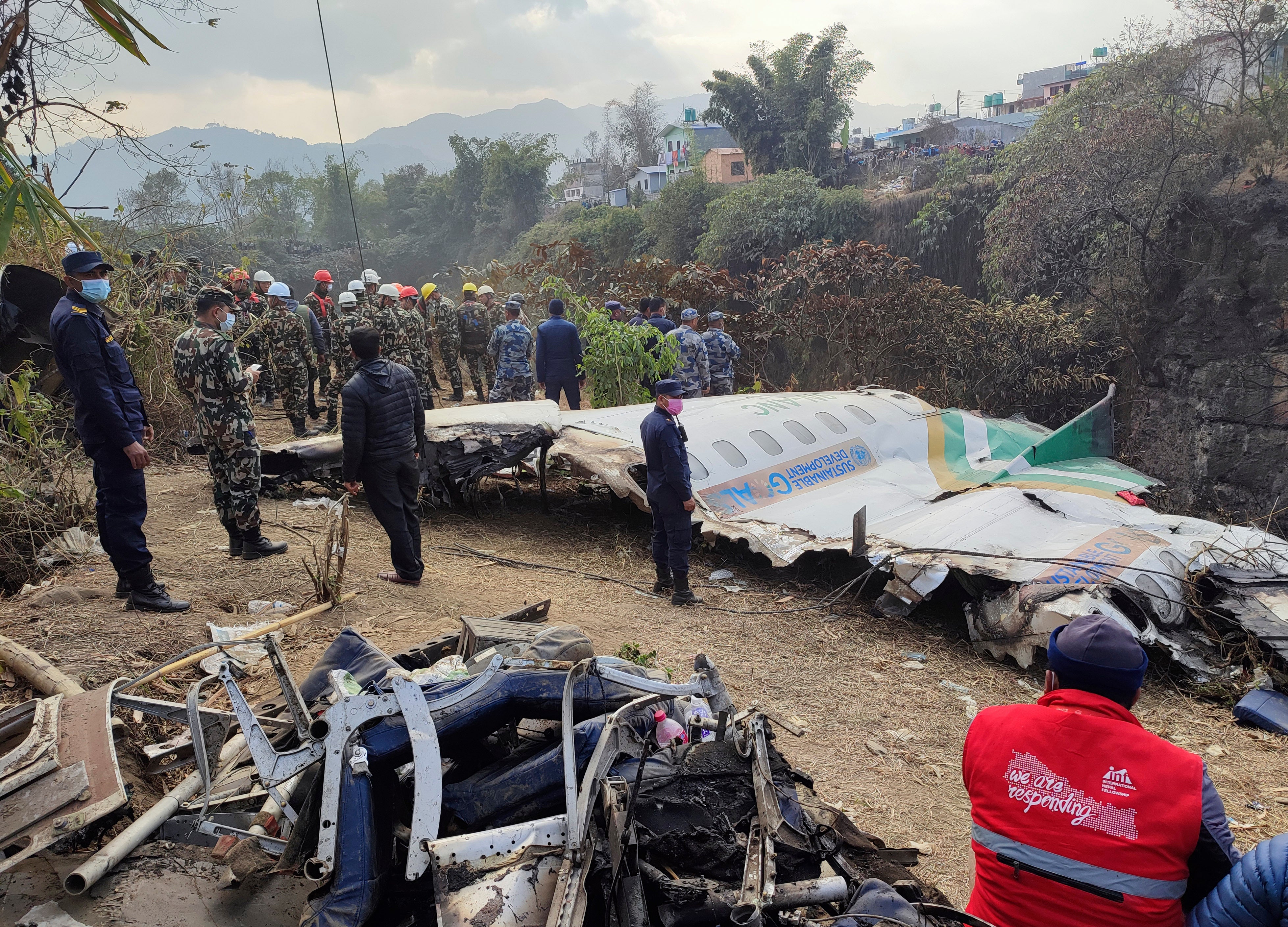 Rescuers stand by wreckage of a passenger plane that crashed in Pokhara