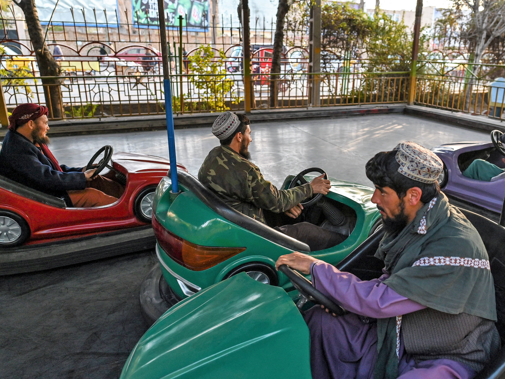 In this picture taken on 23 November, 2021, Taliban fighters ride on bumper cars, while they visit a small amusement park in Herat city, Herat
