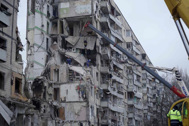 <p>Rescuers work around the apartment building destroyed by a Russian missile strike</p>