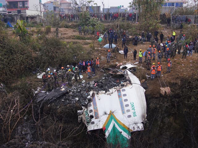 <p>Rescue teams working near the wreckage at the crash site as they look for more bodies</p>