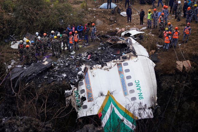 <p>Rescuers scour the crash site in the wreckage of a passenger plane in Pokhara, Nepal, Monday, 16 January 2023 </p>