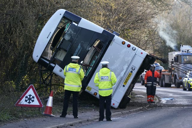 Police at the scene on the A39 Quantock Road in Bridgwater as a double-decker bus is righted by a recovery lorries after it overturned in a crash involving a motorcycle. Picture date: Tuesday January 17, 2023.