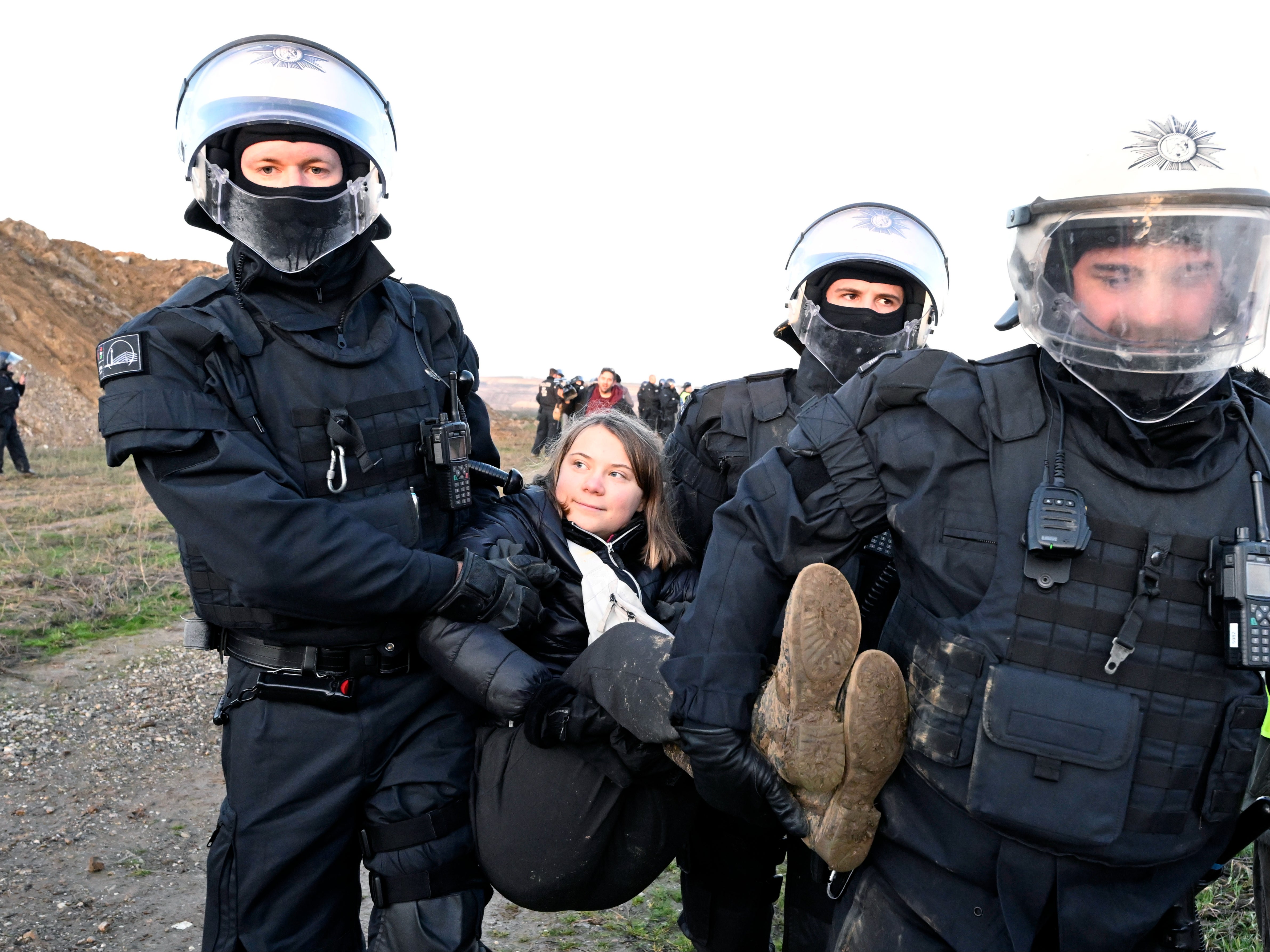 Police officers carry Swedish climate activist Greta Thunberg away from the edge of the Garzweiler II opencast lignite mine