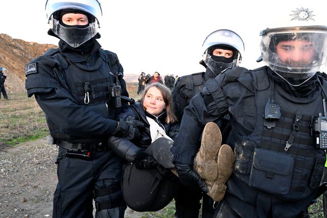 <p>Police officers carry Swedish climate activist Greta Thunberg away from the edge of the Garzweiler II opencast lignite mine</p>
