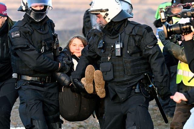 <p>Police officers carry Swedish activist Greta Thunberg away from the edge of the Garzweiler II opencast lignite mine</p>