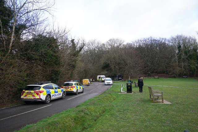 Police at Gravelly Hill in Caterham, Surrey, where a dog attacked members of the public on Thursday. A woman in her 20s was pronounced dead at the scene and a second woman is in hospital receiving treatment for dog bites, her condition is not life-threatening. Armed officers, with support from the National Police Air Service, detained a total of seven dogs at the scene and they are in police custody. Picture date: Friday January 13, 2023.