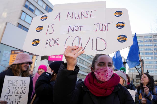 <p>File A NHS nurse holds a placard during a strike, amid a dispute with the government over pay, outside St Thomas’ Hospital in London</p>