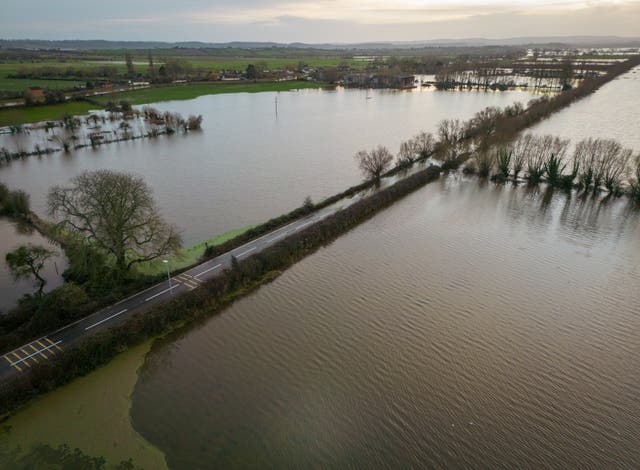 <p>Flood water surrounds the A361 road in Burrowbridge due to widespread flooding of the Somerset Levels</p>