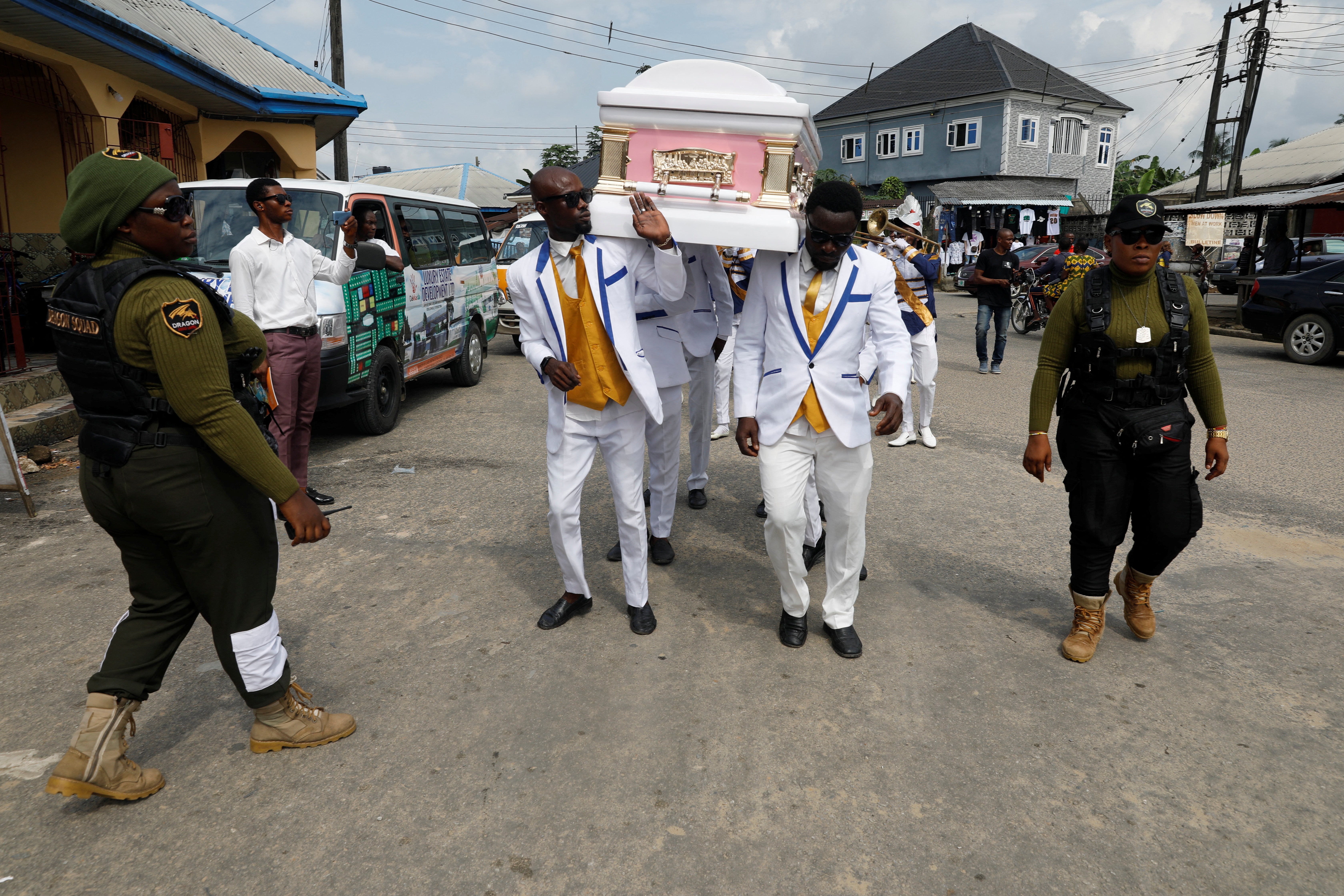 Standing guard beside the pallbearers during a funeral service in Eket