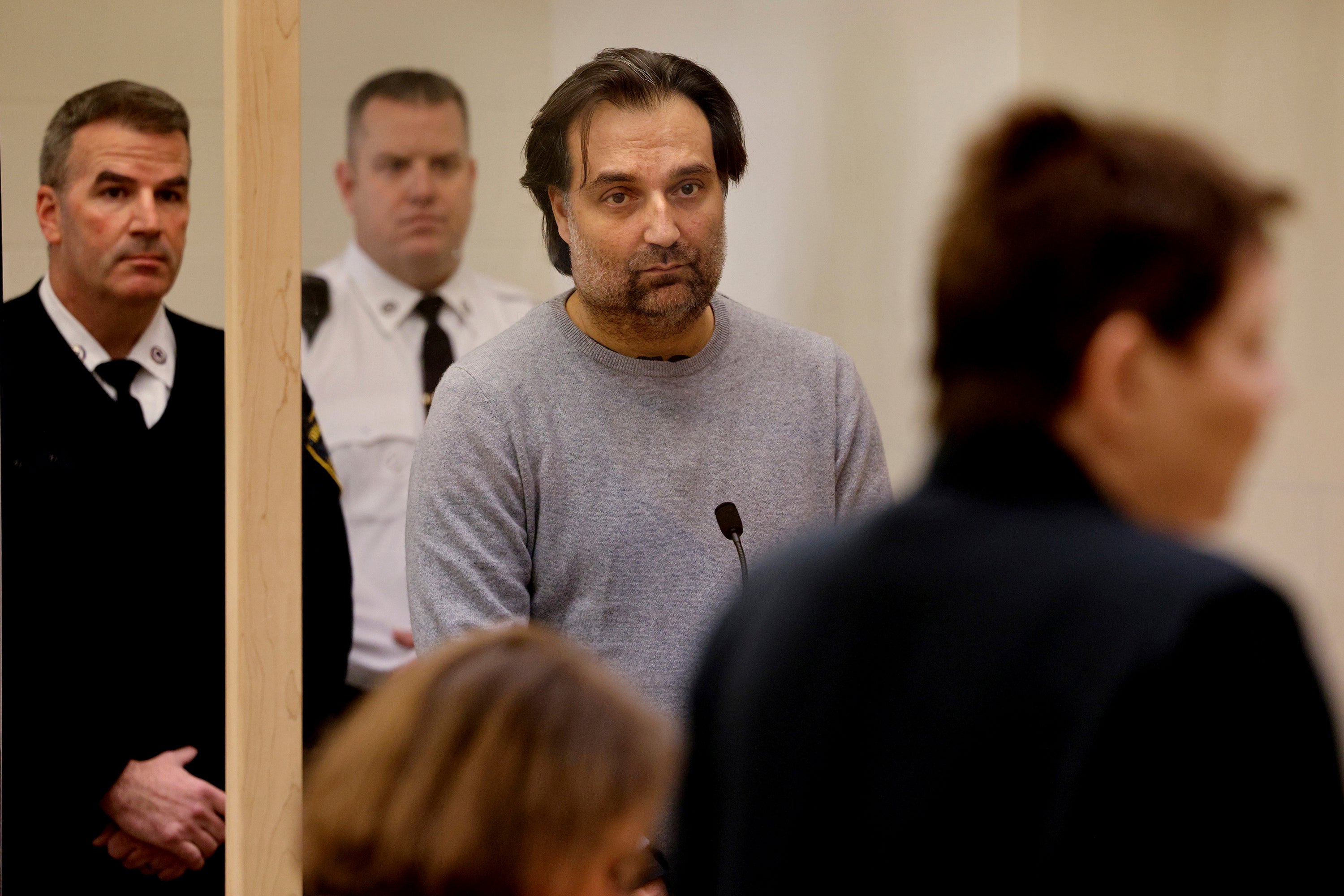 Brian Walshe, center, listens during his arraignment Wednesday, Jan. 18, 2023, at Quincy District Court, in Quincy, Mass., on a charge of murdering his wife Ana Walshe. Not guilty pleas were entered on behalf of Walshe, 47.