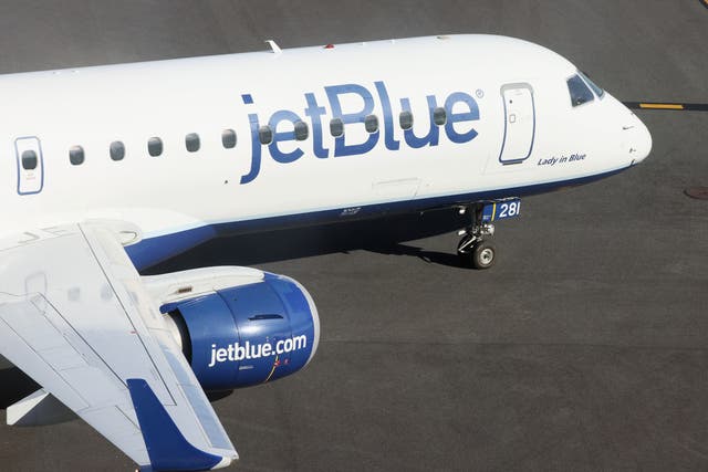 <p>A JetBlue plane on an airport runway </p>
