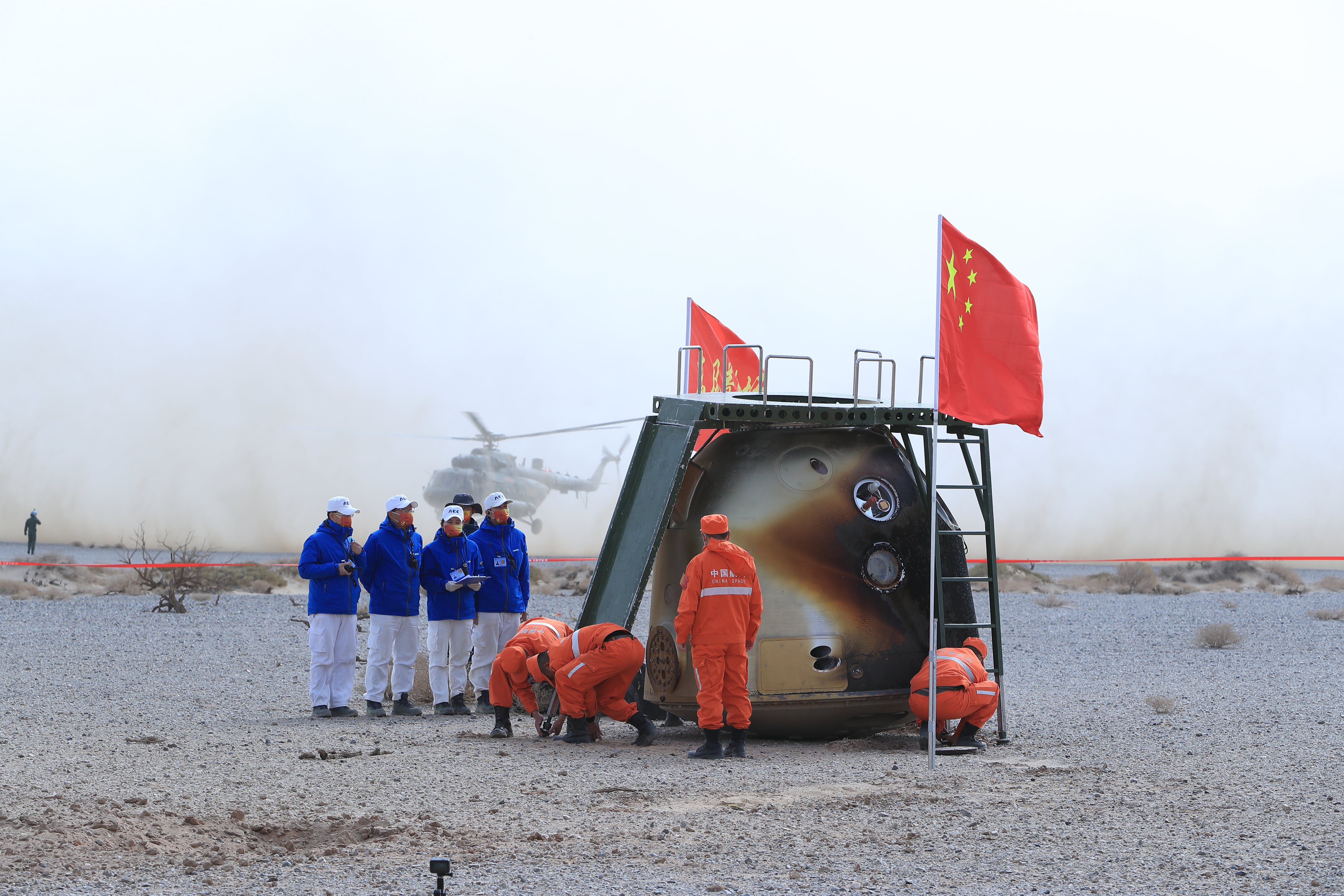 Staff members prepare to help Chinese astronauts disembark from their landing capsule last April, after six months in space as part of the Shenzhou XIII mission