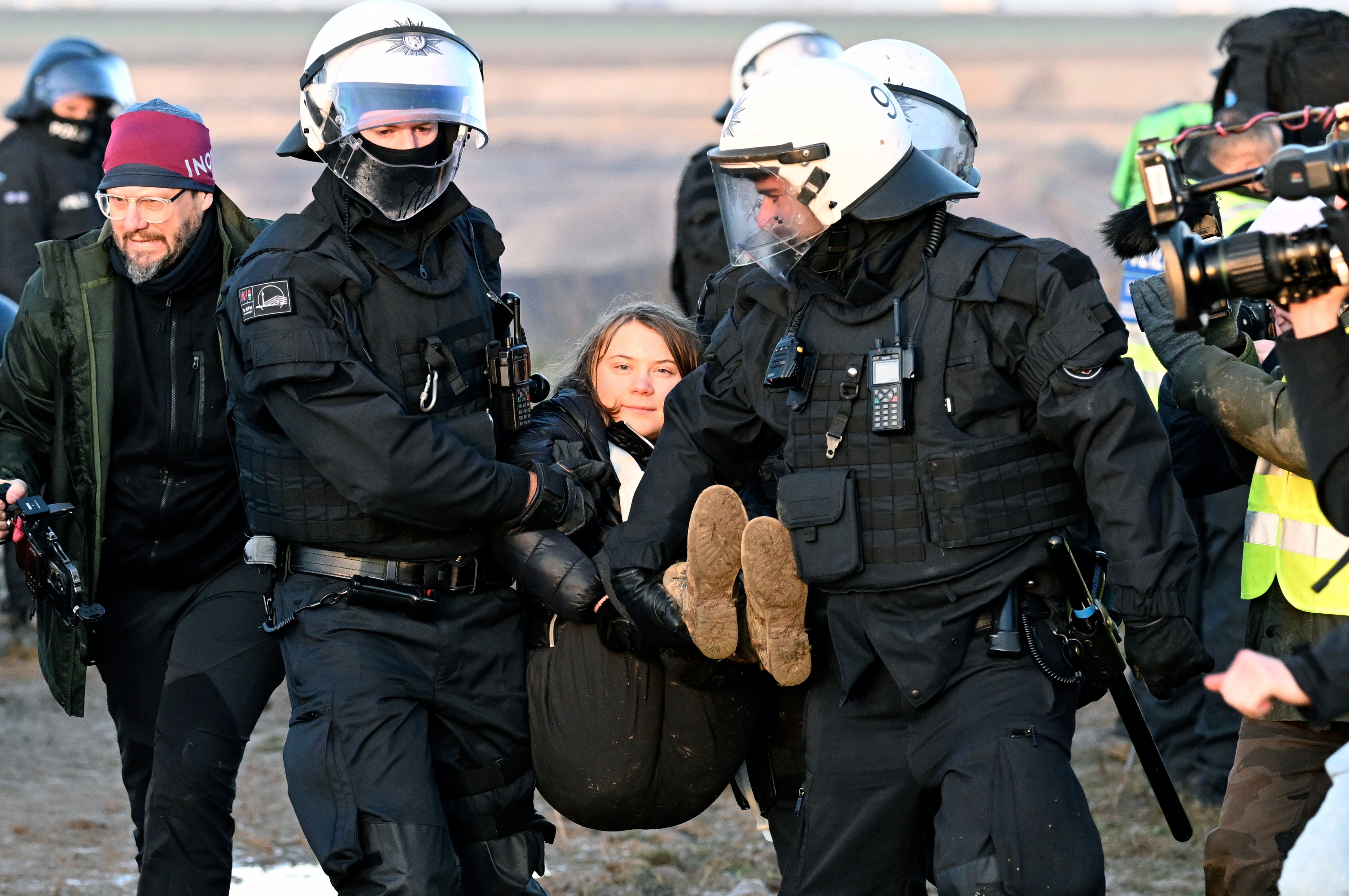 Police officers carry Swedish climate activist Greta Thunberg away from the edge of the Garzweiler II opencast lignite mine during a protest action by climate activists after the clearance of Luetzerath, Germany