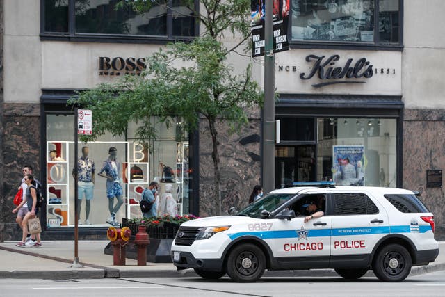 <p>A Chicago Police officer sits in his car as he monitors the area along Michigan Avenue in Chicago, Illinois, on June 18, 2021</p>