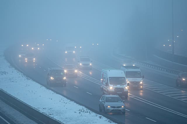 Commuters drive in freezing fog (PA)