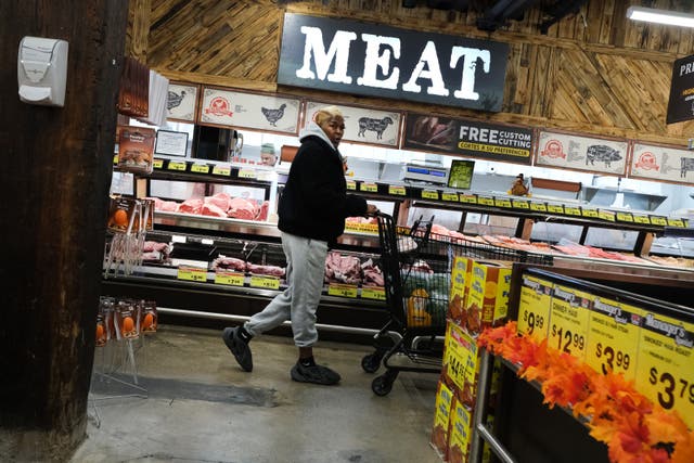 <p>A grocery shopper walks past the meat aisle </p>