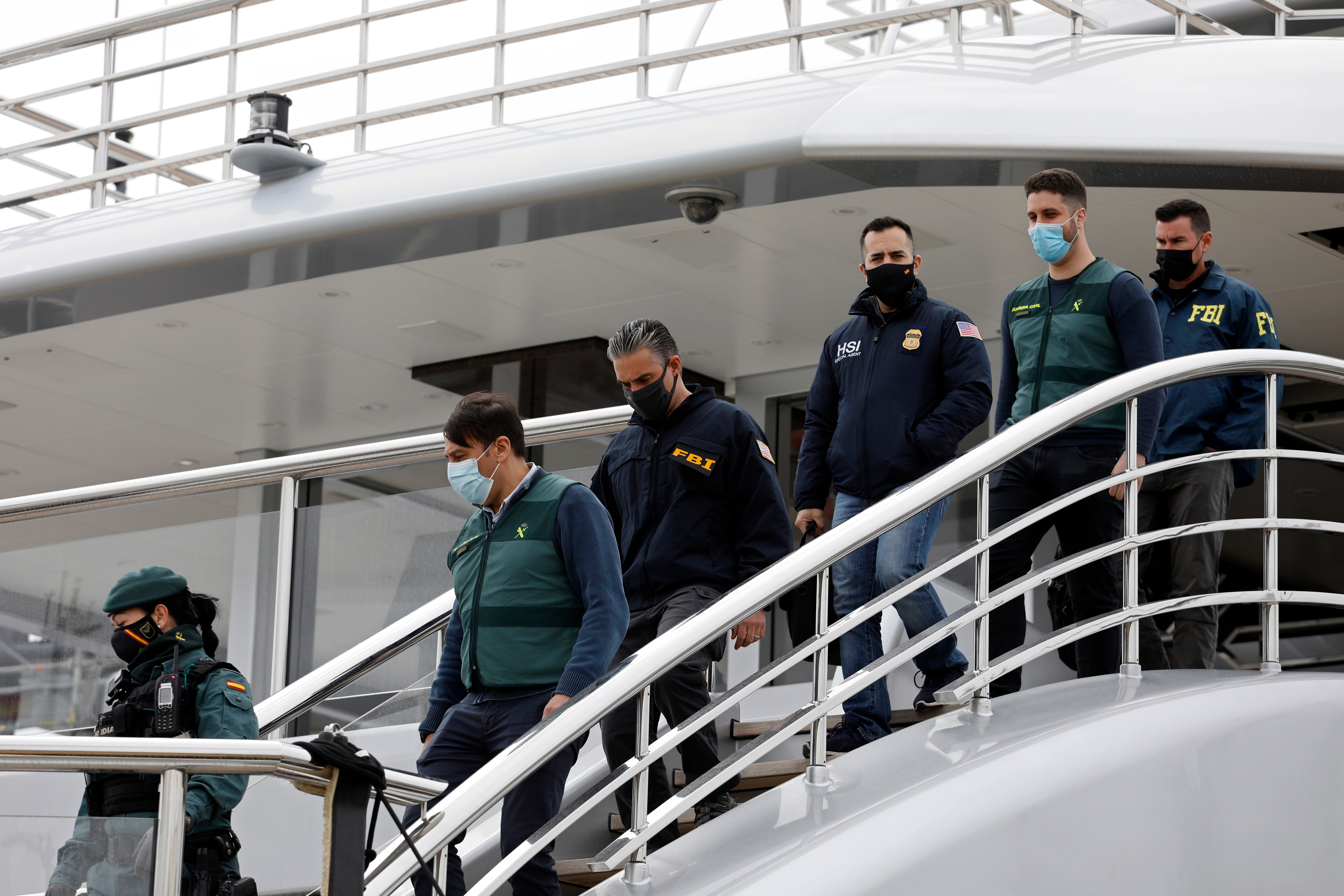 Civil Guards accompany U.S. FBI agents and a U.S.Homeland Security agent from the yacht called Tango