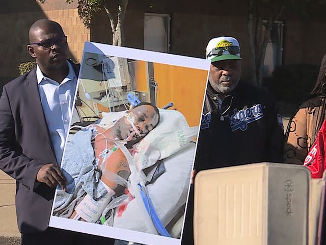 <p>Tyre Nichols' stepfather Rodney Wells, center, stands next to a photo of Nichols in the hospital after his arrest, during a protest in Memphis</p>