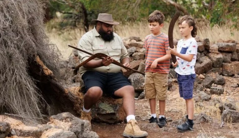 An Aboriginal guide shows kids around his community near the Great Ocean Road in Australia