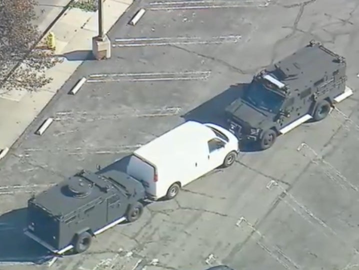 Two SWAT vehicles are seen confronting a white van potentially linked to the Monterey Park shooting