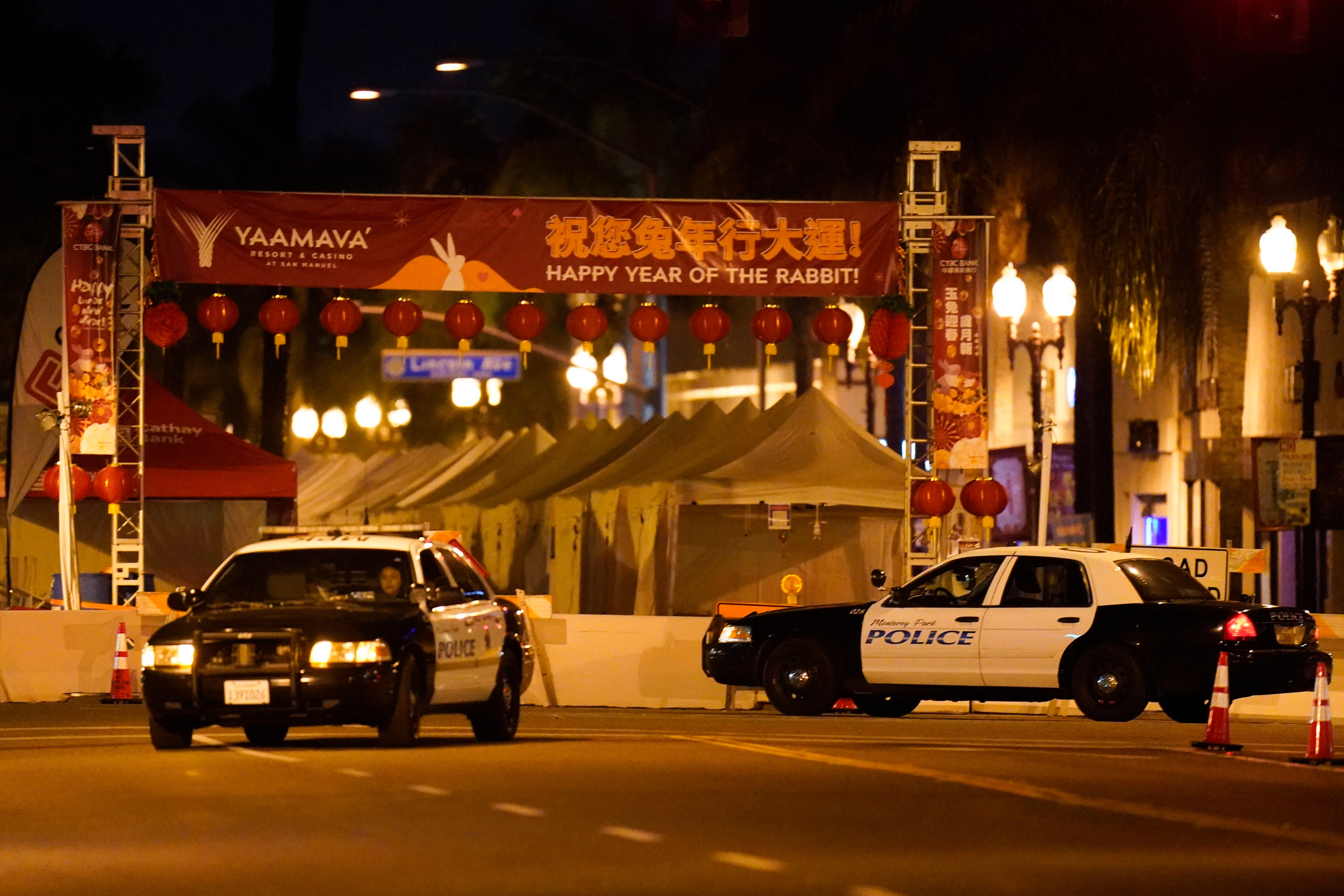 Two police vehicles are seen near a building where a shooting occurred in Monterey Park