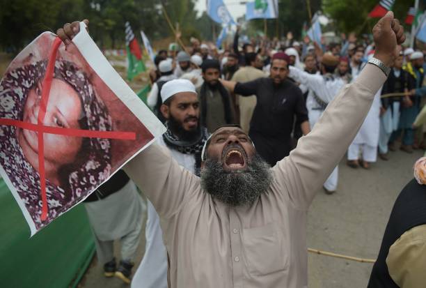 <p>A Pakistani supporter of the Ahle Sunnat Wal Jamaat (ASWJ), a hardline religious party, holds an image of Christian woman Asia Bibi during a protest rally following the Supreme Court’s decision to acquit Bibi of blasphemy in 2018 </p>