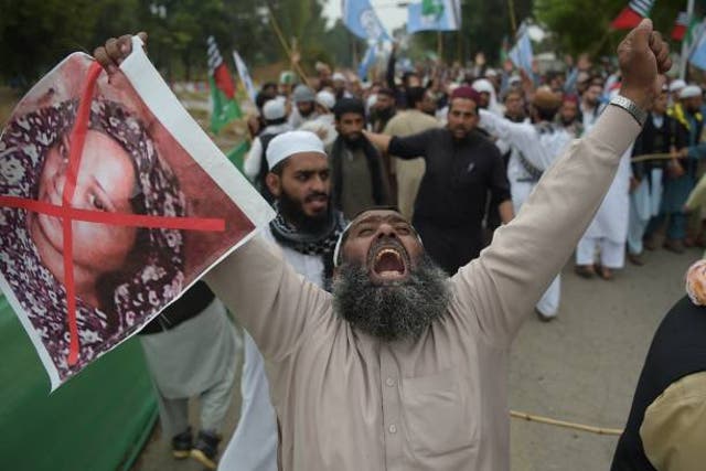 <p>A Pakistani supporter of the Ahle Sunnat Wal Jamaat (ASWJ), a hardline religious party, holds an image of Christian woman Asia Bibi during a protest rally following the Supreme Court’s decision to acquit Bibi of blasphemy in 2018 </p>