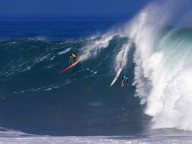 <p>Hawaiian surfer Jake Maki rides a wave as Hawaiian surfer Keala Kennely gets wiped out during The Eddie Aikau Big Wave Invitational surfing contest on January 22, 2023</p>