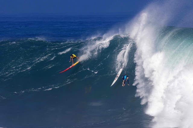 <p>Hawaiian surfer Jake Maki rides a wave as Hawaiian surfer Keala Kennely gets wiped out during The Eddie Aikau Big Wave Invitational surfing contest on January 22, 2023</p>