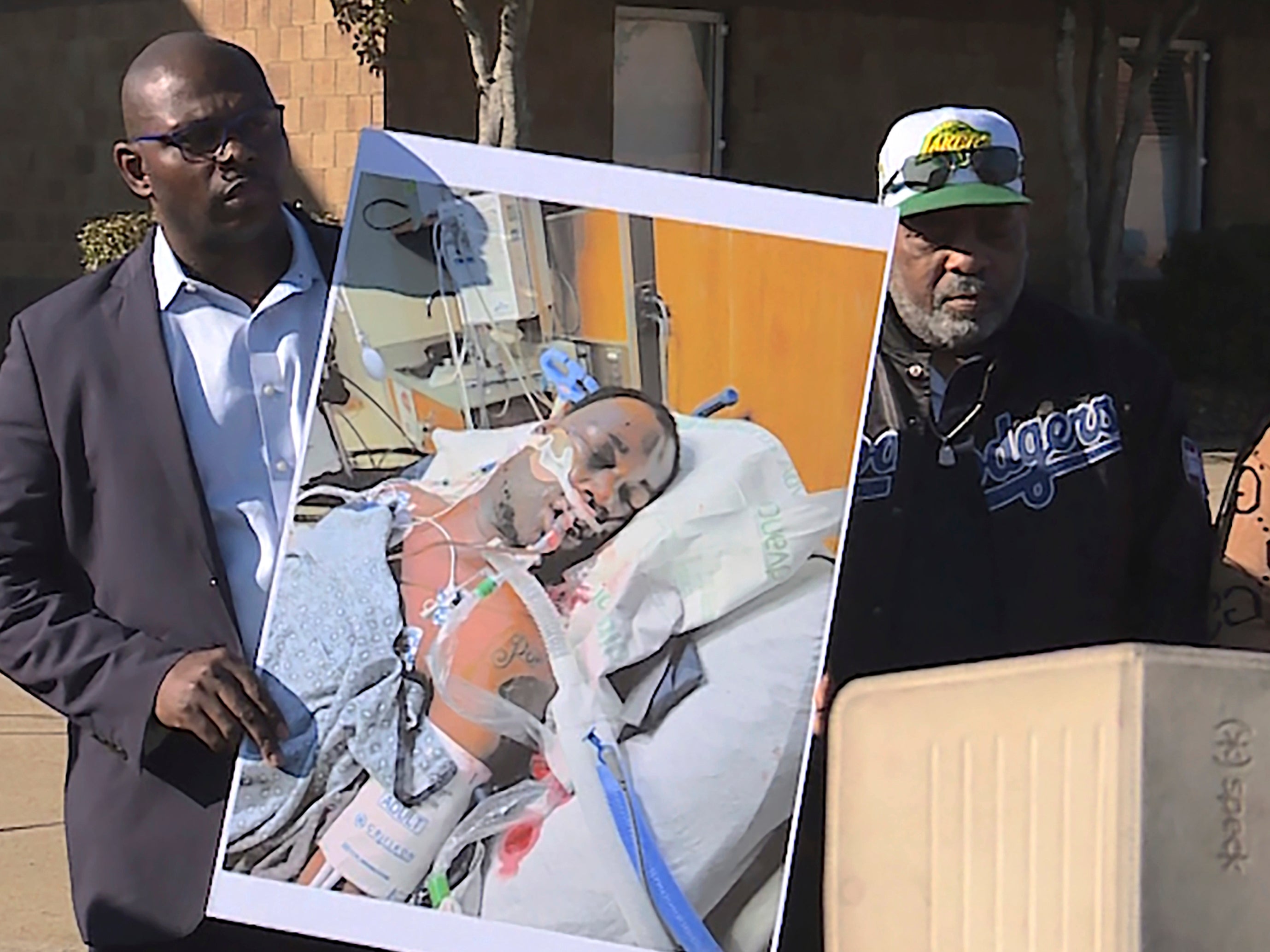 Tyre Nichols' stepfather Rodney Wells, centre, stands next to a photo of Nichols in the hospital after his arrest, during a protest in Memphis, Tennessee