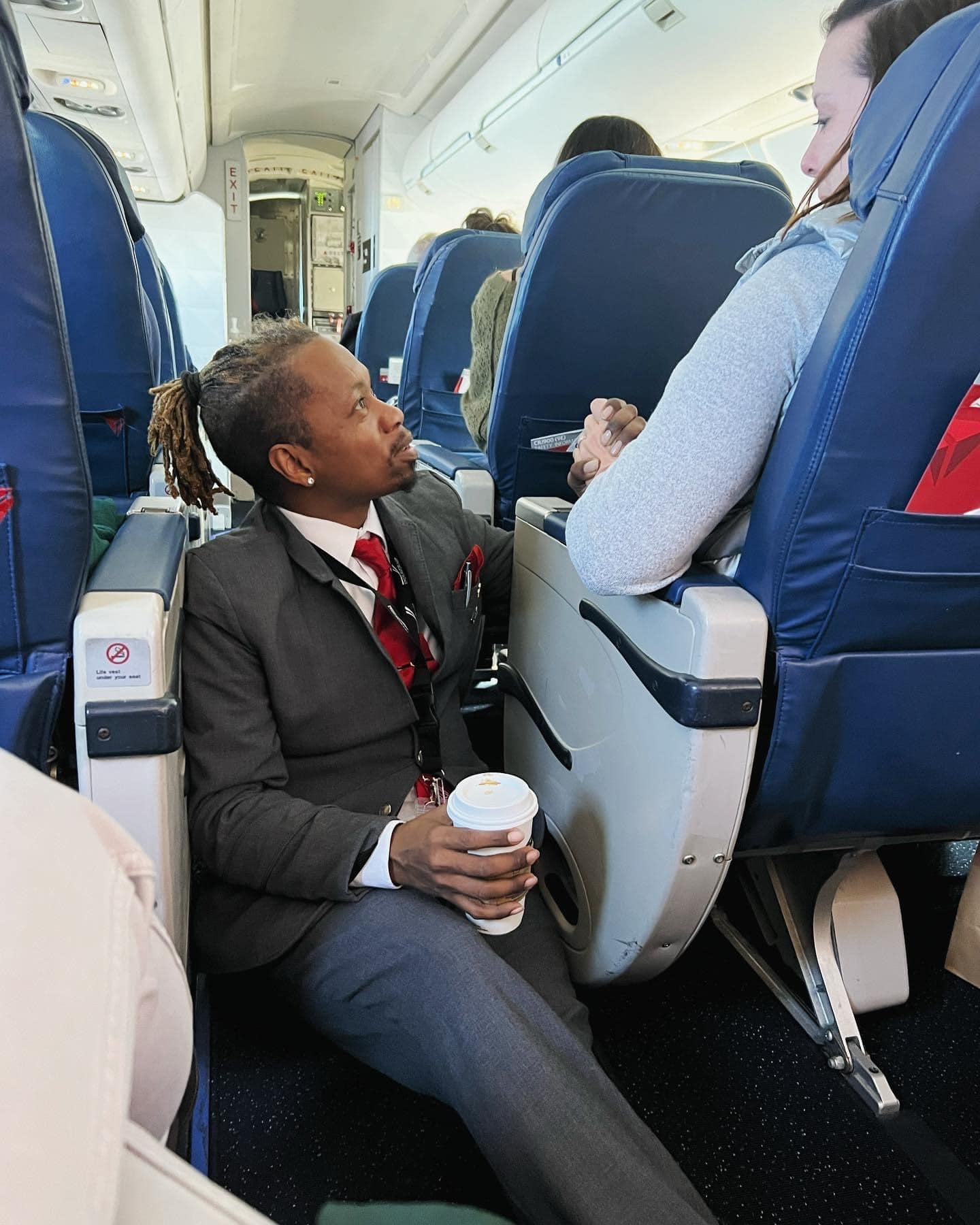 The Delta crew member sat in the aisle to hold the passenger’s hand