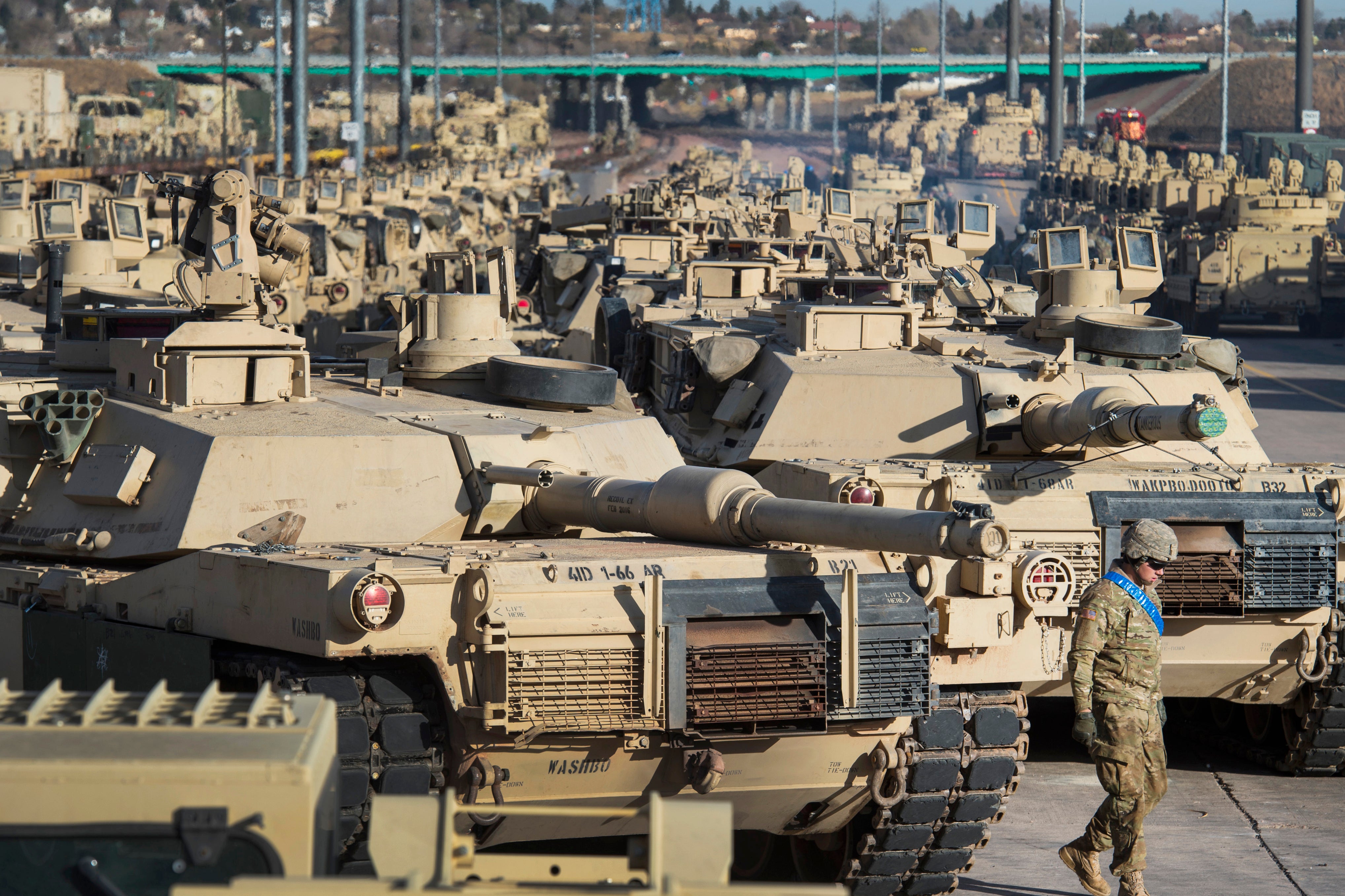 A soldier walks past a line of M1 Abrams tanks at Fort Carson in Colorado Springs, Colorado